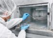 Operatore con DPI esegue un campionamento microbiologico con tampone all’interno di una condotta aeraulica, con piastra Petri in mano