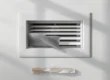 Griglia di ripresa aria smontata con il filtro estraibile appena rimosso durante la pulizia domestica