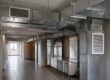 Condotte aerauliche a vista in acciaio zincato nel corridoio delle parti comuni di un condominio