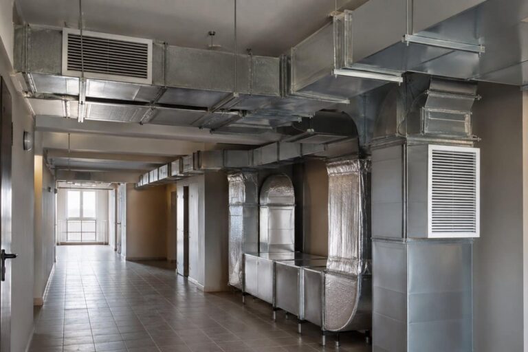 Condotte aerauliche a vista in acciaio zincato nel corridoio delle parti comuni di un condominio