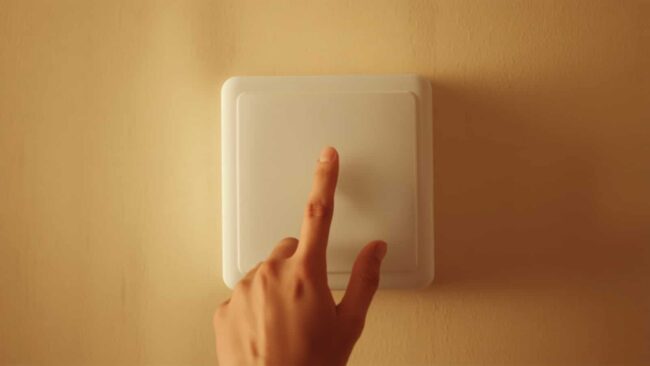 Persona regola la temperatura dello scaldabagno di casa per prevenire la Legionella