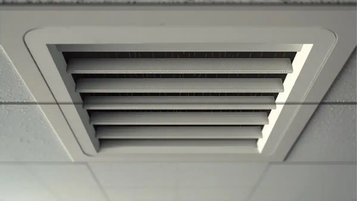 Bocchetta di ventilazione a soffitto con alette impolverate e aloni sul controsoffitto