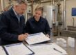 Due tecnici esaminano il Piano di Sicurezza dell'Acqua con schema dell'impianto idrico e campioni d'acqua per il controllo della Legionella