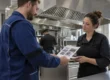 Tecnico AirBio consegna il certificato di pulizia della cappa con rapporto fotografico alla titolare di un ristorante
