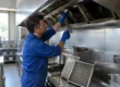 Tecnico AirBio esegue la pulizia di una cappa industriale in una cucina professionale secondo la normativa