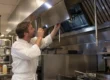 Chef controlla i filtri della cappa del ristorante per decidere quando programmare la pulizia professionale