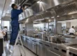 Tecnico AirBio ispeziona la cappa a isola della cucina di un hotel insieme allo chef executive
