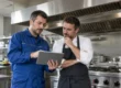 Tecnico AirBio illustra a un ristoratore il preventivo per la pulizia della cappa industriale della sua cucina