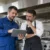 Tecnico AirBio illustra a un ristoratore il preventivo per la pulizia della cappa industriale della sua cucina