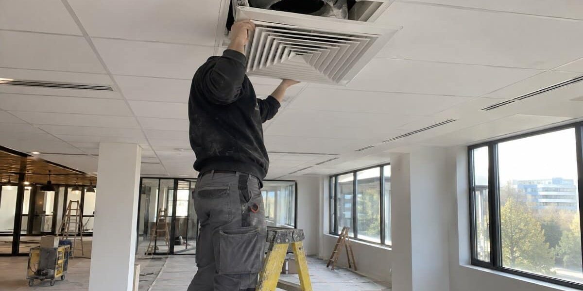 Pulizia condotte dopo ristrutturazione: smontaggio del diffusore tecnico su scala smonta un diffusore a soffitto coperto di polvere di cartongesso per la pulizia delle condotte dopo una ristrutturazione
