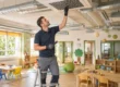 Tecnico ispeziona una bocchetta di ventilazione a soffitto in un'aula di asilo nido durante un controllo dell'impianto