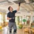 Tecnico ispeziona una bocchetta di ventilazione a soffitto in un'aula di asilo nido durante un controllo dell'impianto